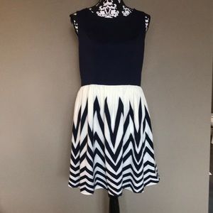 Navy stretch rounded neck sleeves less dress with cream and navy flowy bottom.